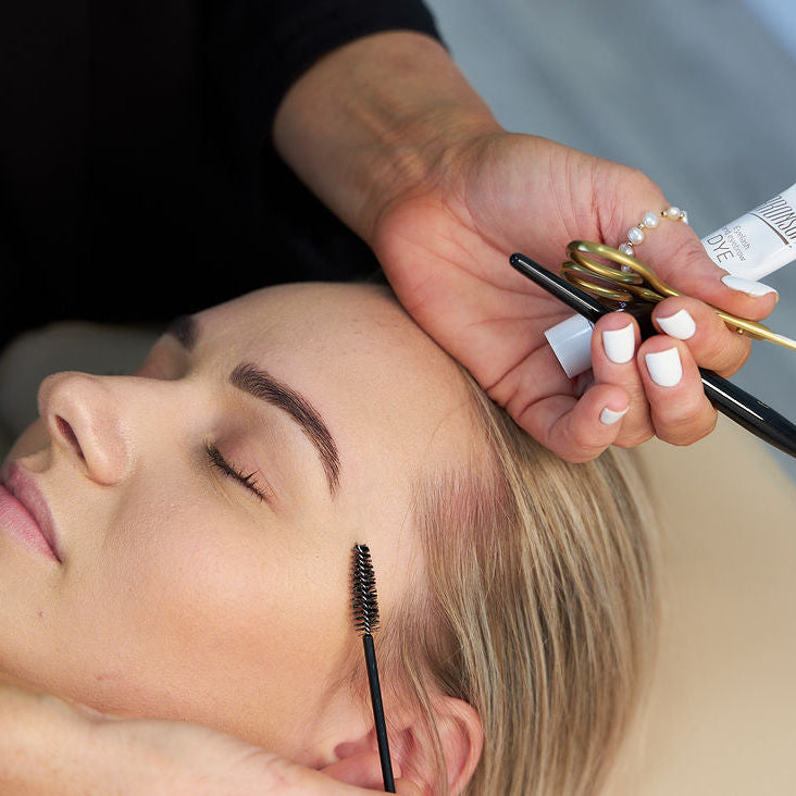 "Image of a lash and brow stain package, featuring perfectly tinted lashes and eyebrows. The treatment enhances natural features with rich, long-lasting color, providing a polished and defined look."

